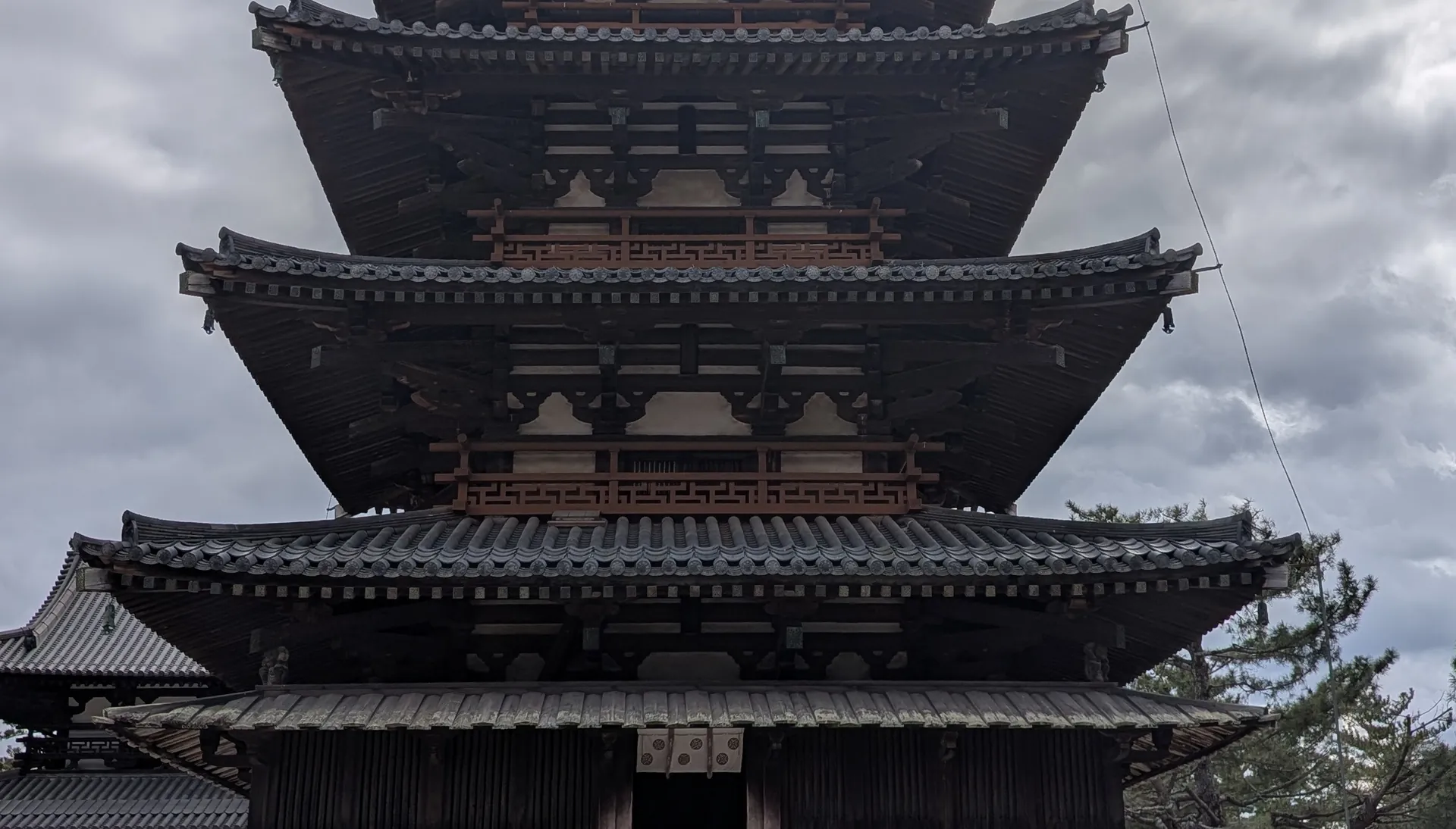 五重塔の屋根と軒を横長に切り出した写真。屋根の下に組物が並ぶ